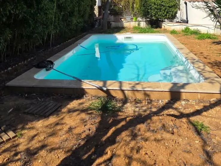 Avant : piscine entourée de terre nue