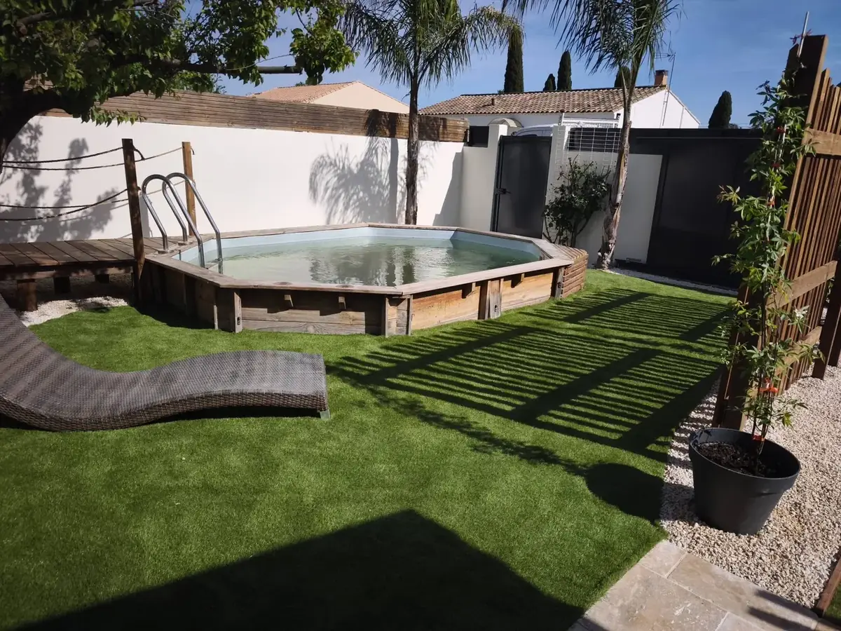 Piscine hors sol en bois entourée de gazon synthétique